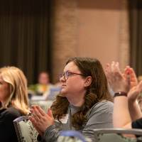 people at tables applauding